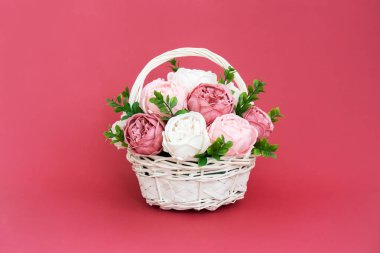 Çiçek açan çiçekler: Pembe arka planda saman sepetinde pembe ve beyaz şakayık çiçekleri.