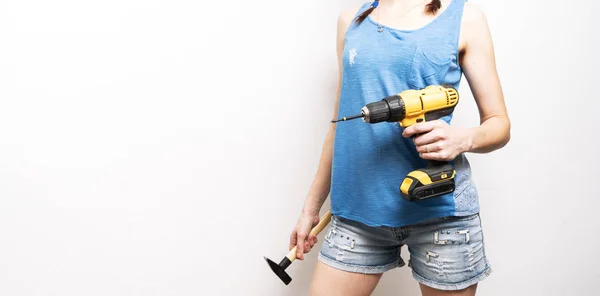Mujeres en el trabajo: una chica lleva un destornillador amarillo en las manos. — Foto de Stock