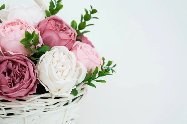 Flores em flor: Buquê de peônias rosa e branca em uma cesta de palha em um fundo branco . — Fotografia de Stock