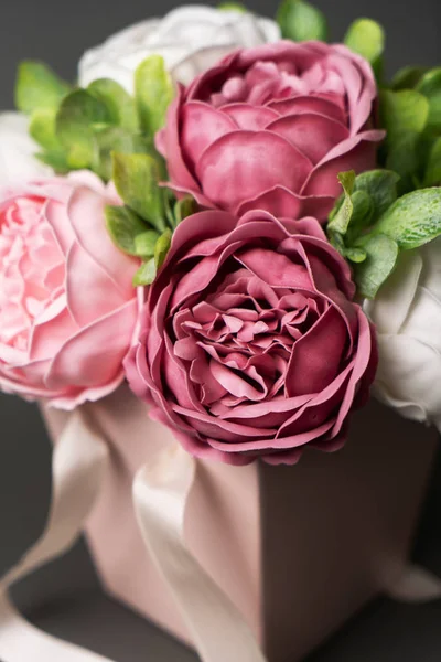 Flores en flor: Ramo de peonías lila y rosa en una caja cuadrada rosa sobre un fondo gris . — Foto de Stock