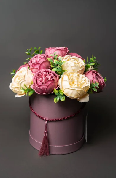 Flores en flor: Ramo de peonías rosas en una caja rosa sobre un fondo gris . —  Fotos de Stock
