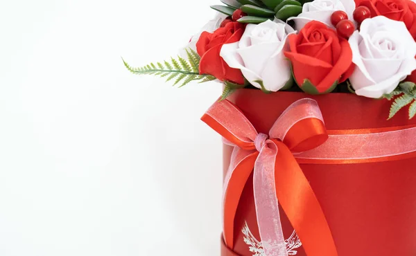 Flores en flor: Un ramo de rosas rojas y blancas en una caja redonda roja sobre un fondo blanco . — Foto de Stock