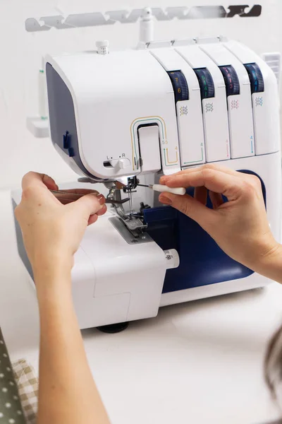 Mulheres no trabalho: Menina enfiando a agulha de uma máquina de costura. — Fotografia de Stock