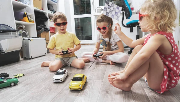 Childrens hobbies: Children play at home with radio-controlled models of cars and organized racing competitions. — Stock Photo, Image