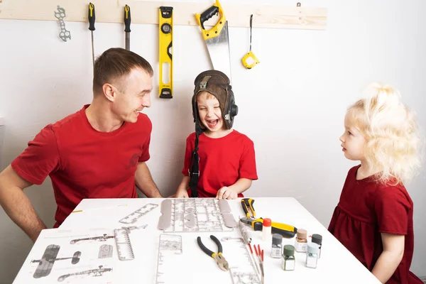 Tempo de família: pai com dois filhos filho e filha coleta um avião modelo . — Fotografia de Stock