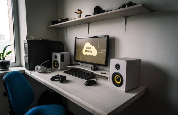 Cloud gaming: the workplace of a professional gamer with a monitor, gamepad, headphones and an armchair. — Stock Photo, Image