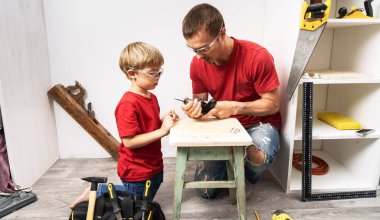 Baba oğluna el matkabıyla çalışmayı öğretiyor..