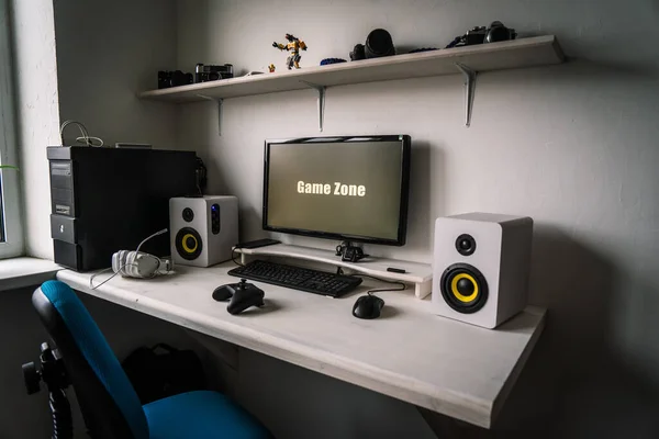 De werkplek van een professionele gamer met een monitor, gamepad, hoofdtelefoon en een fauteuil. — Stockfoto