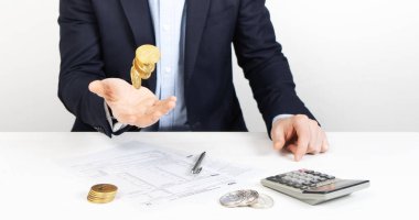 Taxation: a man fills out a tax return and tosses cryptocurrency coins in his hand. Close-up of hands.