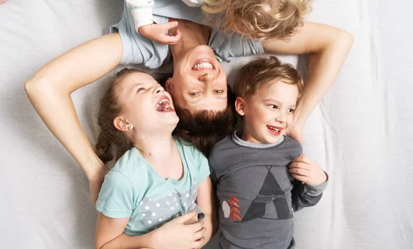Tiempo Familia Mamá Tres Niños Yacen Una Cama Blanca Abrazándose —  Fotos de Stock