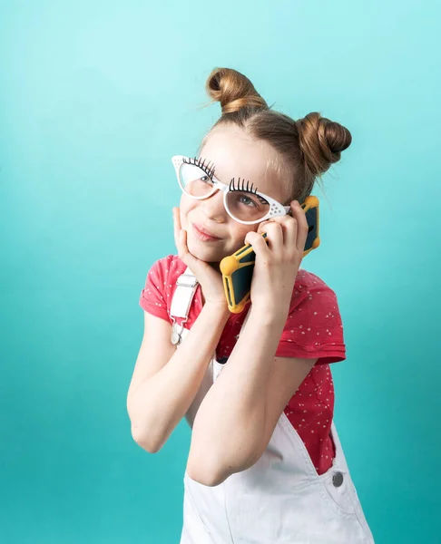 Beauty industry: A girl with glasses and false eyelashes makes a phone call and gossips.