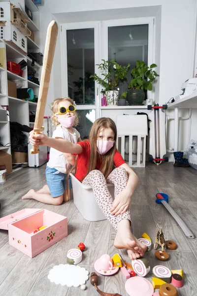 Μείνετε στο σπίτι: Τα παιδιά με ιατρικές μάσκες παίζουν με τα παιχνίδια και βόλτα σε ένα λευκό κουτί. — Φωτογραφία Αρχείου