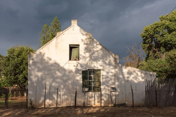 Antigua casa en De Rust contra el telón de fondo de nubes oscuras — Foto de Stock
