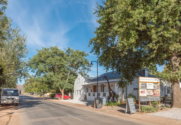 Escena callejera con un restaurante y una estatua de jirafa en Greyton — Foto de Stock