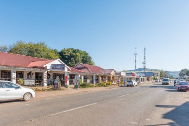 Graskop 'ta iş yerleri, araçlar ve insanların olduğu sokak sahnesi.
