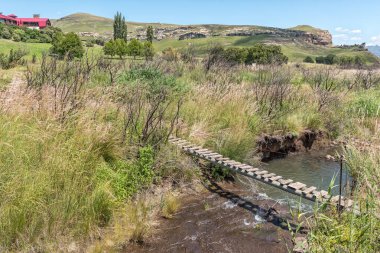 GOLDEN GATE HIGHLANDS ULUSAL PARK, GÜNEY AFRİKA - 3 Mart 2020: Golden Gate 'deki otelden Brandwag payandasına giden yolda Little Caledon Nehri üzerindeki yaya köprüsü
