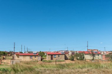 PHUTHADITJHABA, Güney Afrika - 18 Mart 2020: Özgür Eyalet Eyaleti 'ndeki Phuthaditjhaba' da R712 yolunun yanındaki evler