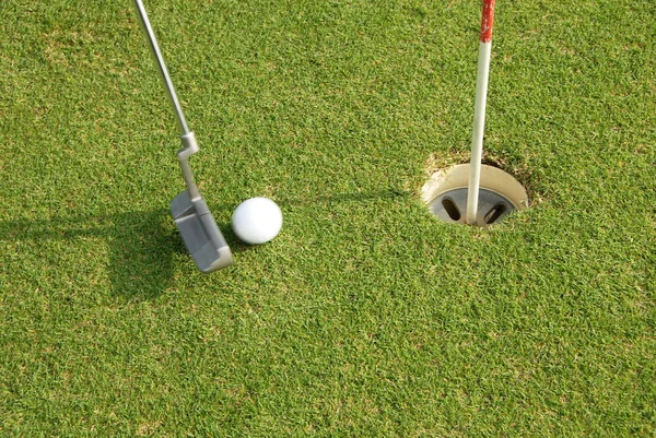 Golfista uvedení míč do díry — Stock fotografie