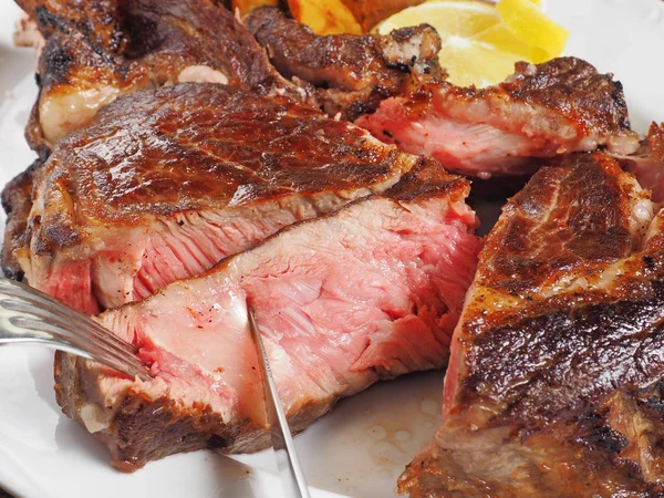 Kniven skär bit grillat kött — Stockfoto