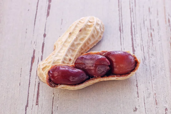 Jordnötter i skal på trä bakgrund — Stockfoto