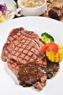 Beyaz tabakta sebze ile kaburga eti