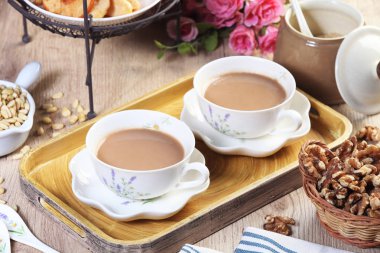 Ahşap masa üzerinde süt çay