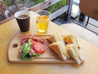  Omlet sandviç domates, salata ve ahşap tahta üzerinde pastırma ile    