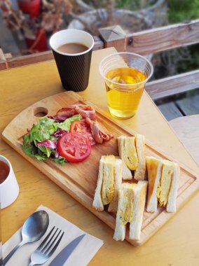  Omlet sandviç domates, salata ve ahşap tahta üzerinde pastırma ile    