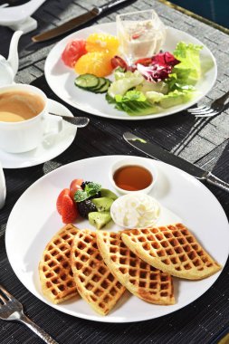 Kahvaltı için taze meyve ve kremalı waffle.