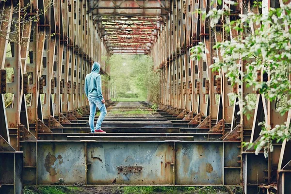 Грустный человек на заброшенном мосту — стоковое фото