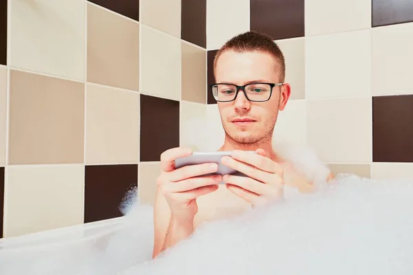 Hombre usando el teléfono móvil en el baño — Foto de Stock