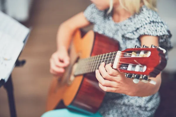 Dziewczyna uczy się grać na gitarze — Zdjęcie stockowe