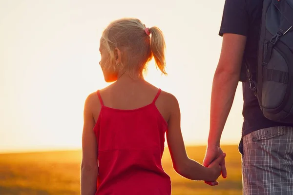 Девушка держит за руку своего отца — стоковое фото