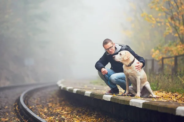 Человек, путешествующий со своей собакой на поезде — стоковое фото