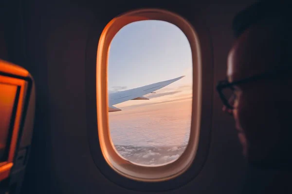 Mann blickt durch Fenster des Flugzeugs — Stockfoto