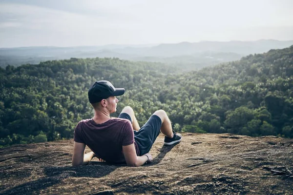 Man resting on rock over jungle — Stock Photo, Image