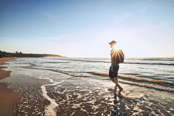 Viajante na praia ao nascer do sol — Fotografia de Stock