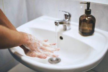 Evde, banyoda ellerini yıkamak. Sağlıklı yaşam tarzı, hijyen ve önleme viral ve bakteriyel hastalıklar. 