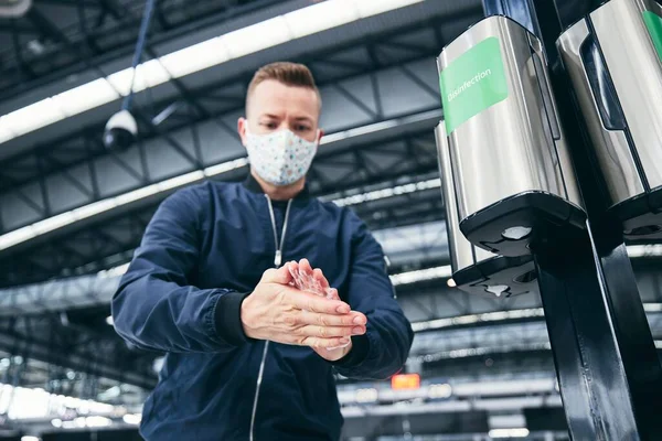 在机场 男人戴着面具 用手部清洁剂 大流行病 卫生和个人保护期间的旅行主题 — 图库照片