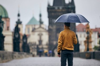 Boş Charles Köprüsü 'nde şemsiyeli yalnız bir adam. Prag Çek Cumhuriyeti