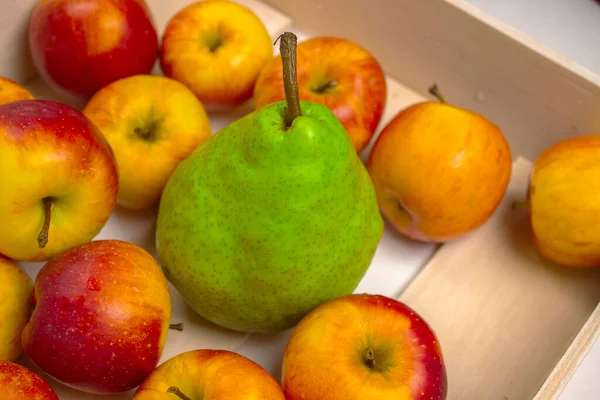 The apples are in a white wooden box on a white background. Red and yellow ripe apples.