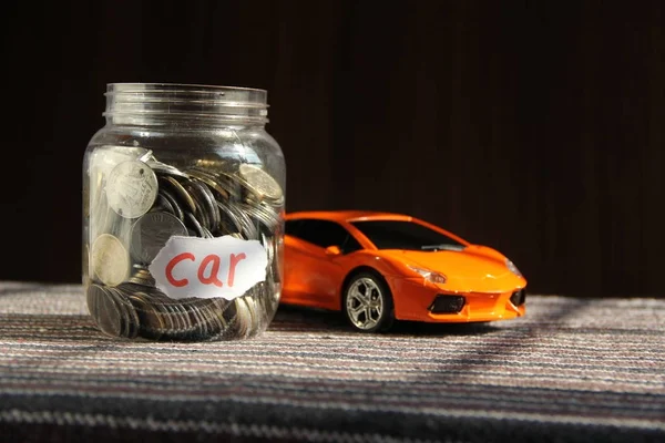 Coins in money jar with car label