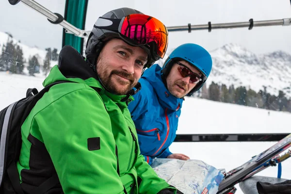 Happy skiers sitting in gondola lift — Stock Photo, Image