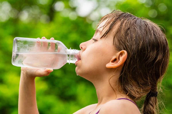 Menina bebendo água da torneira limpa de garrafa de plástico transparente — Fotografia de Stock