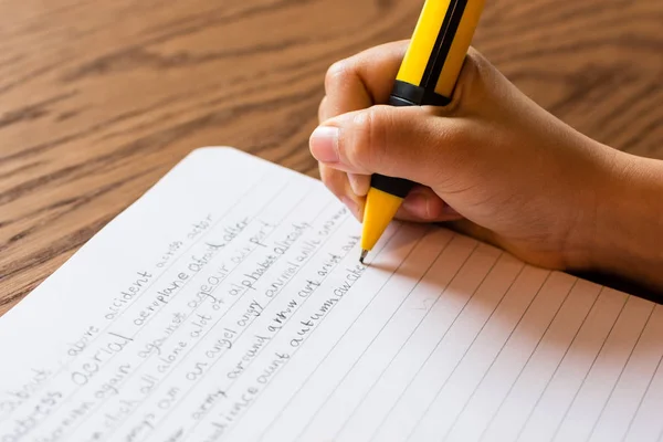 Chica escribiendo a mano en el bloc de notas — Foto de Stock