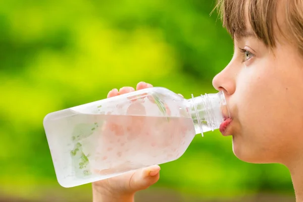 Girl dricka rent kranvatten från genomskinlig plastflaska — Stockfoto