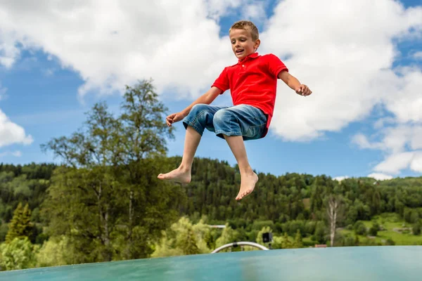 Child jumping on trampoline — Stock Photo, Image