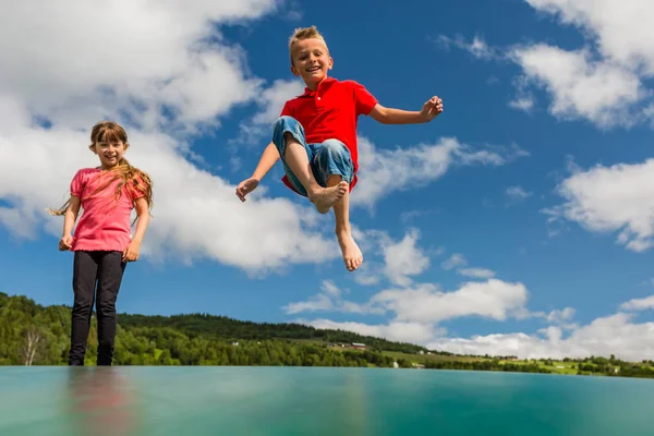 Barn studsar upp och ner på studsmatta — Stockfoto