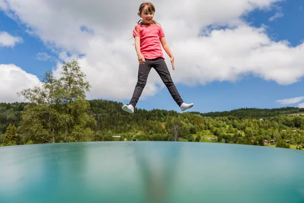 Flickan hoppar på bouncy kudde — Stockfoto