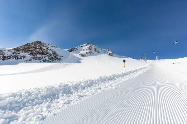 Declive de esqui recém-preparado em um dia ensolarado — Fotografia de Stock